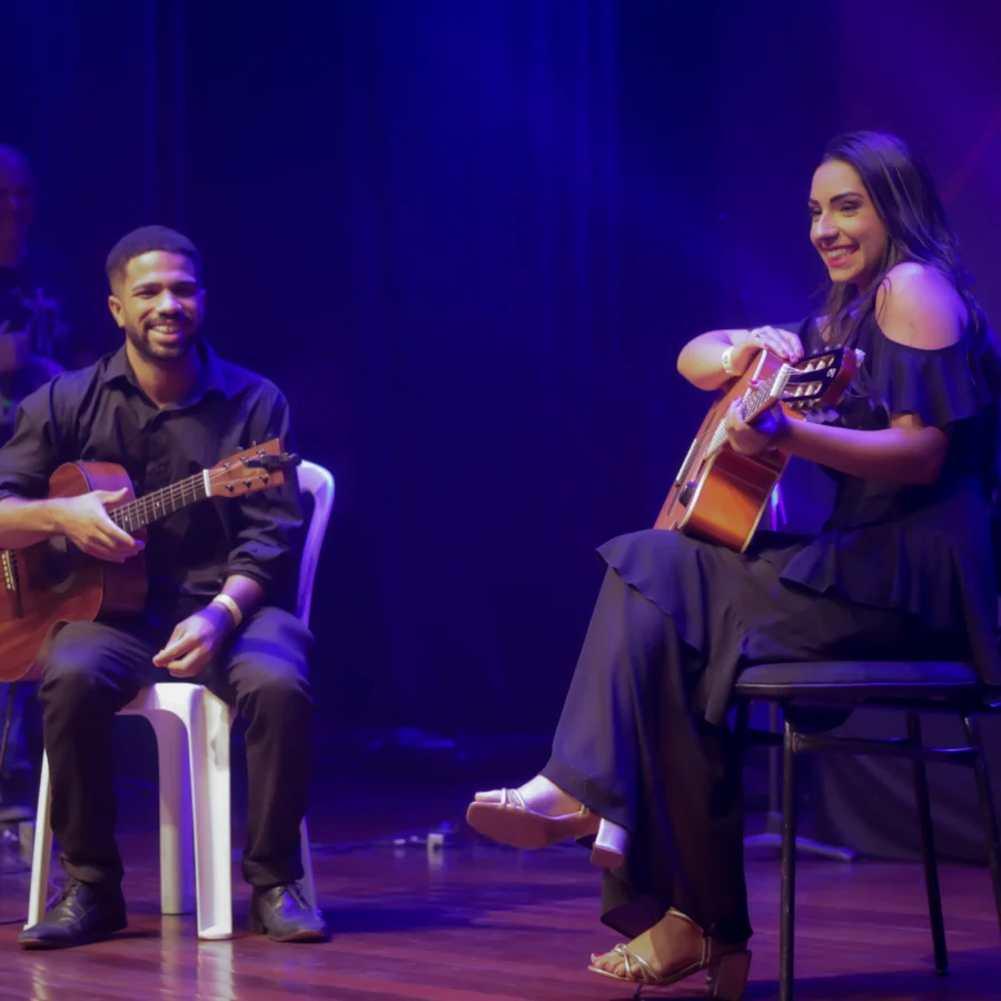 Alunos do Espaço Fermata tocando violão juntos no palco
